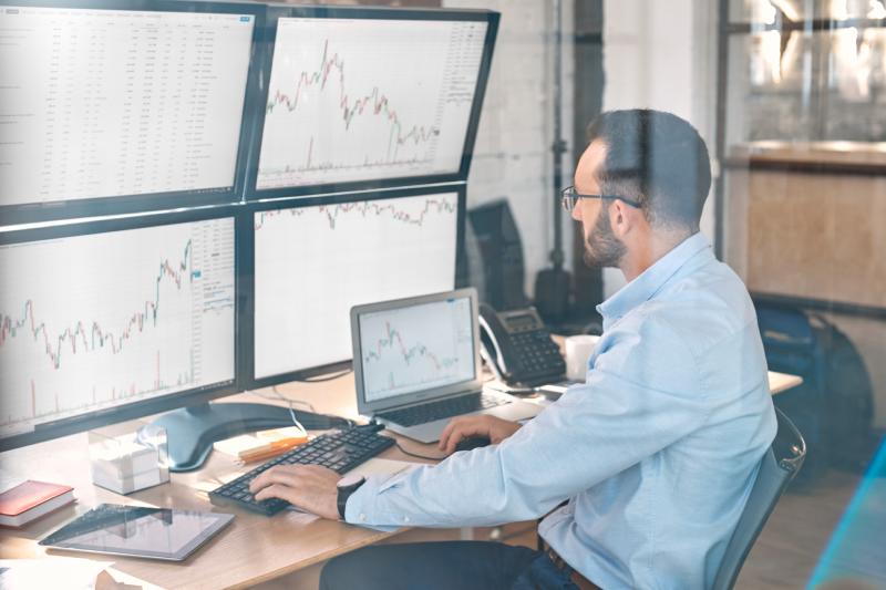 Trader at desk using multiple monitors